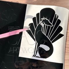 a pink toothbrush sitting on top of a black and white book with an image of a bird