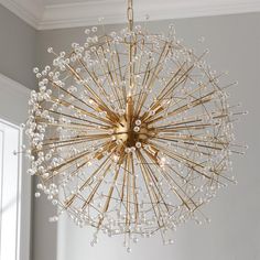 a chandelier hanging from the ceiling in a room with white walls and windows