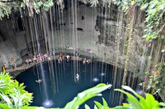 several people are standing in the water inside a cave