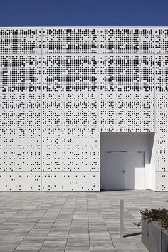 a white building that has some planters in front of it