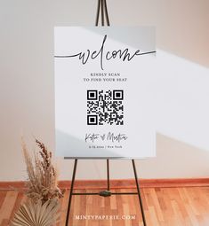 a welcome sign on a easel with a potted plant