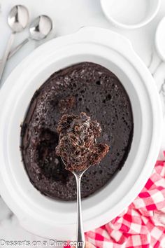 a white bowl filled with chocolate cake on top of a red and white checkered table cloth