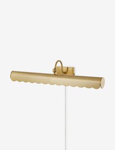 a wall light that is on top of a white pole and has a gold finish