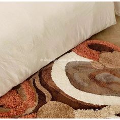 a bed with white pillows and a brown rug on the floor