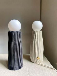 two ceramic lamps sitting next to each other on a table