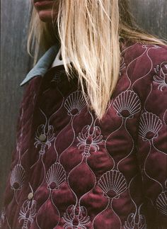 a woman with long blonde hair wearing a red jacket