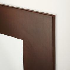 a close up of a mirror on a wall with a white and brown border around it