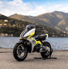 a yellow and white motorcycle is parked by the water