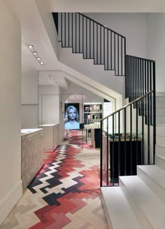 the hallway is decorated with colorful carpet and black railings