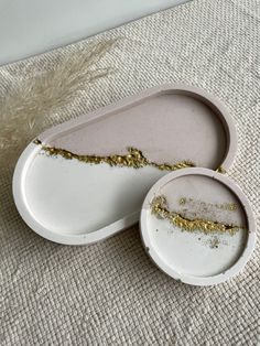 two white dishes with gold splatters on them