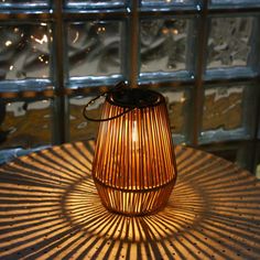 a light that is sitting on top of a table in front of some glass windows