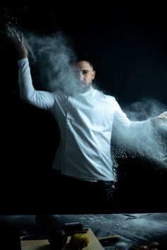 a man standing in the middle of some powdered food on top of a table