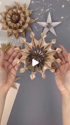 two hands are holding up some paper stars