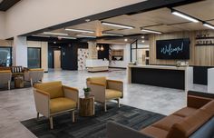 an office lobby with couches, chairs and a reception counter in the center area