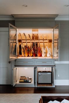 a room with guitars and other musical instruments on the wall above it is a built - in entertainment center