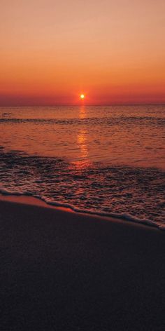 the sun is setting over the water at the beach