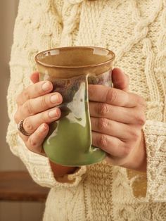 a woman holding a cup in her hands