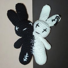 two black and white crocheted stuffed animals next to each other