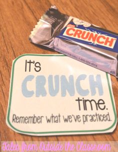 some candy bars are sitting on top of a wooden table next to a sign that says it's crunch time