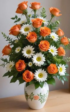 an arrangement of orange roses and white daisies in a vase