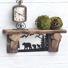 a wooden shelf with a bear and two bears on it next to a pine cone