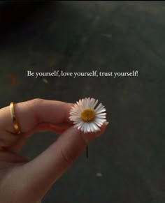 a person holding a flower in their hand with a quote on the side that says be yourself, love yourself, trust yourself