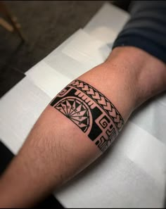 a man's arm with a tattoo on it sitting on top of a table