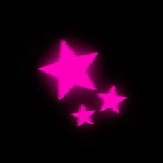 three pink stars are glowing in the dark