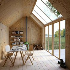 a room with wooden walls and flooring that has glass windows