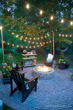 an outdoor fire pit with lights strung over it