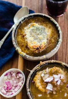 two bowls filled with soup on top of a wooden table