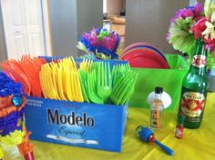 there is a table set up with colorful plates and napkins on top of it