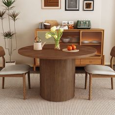 a dining room table with two chairs and a vase filled with flowers on top of it