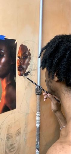 a man with dreadlocks is painting a woman's face on a wall