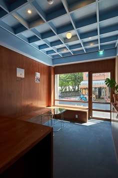 an empty room with wood paneling and glass doors leading to the outside patio area