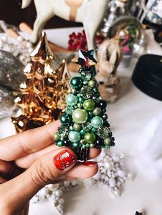 a hand holding a small christmas tree decoration