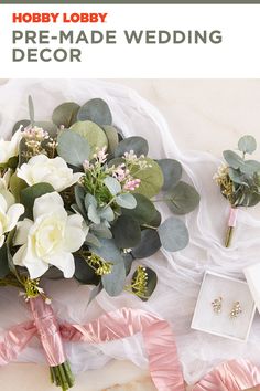 a bouquet of flowers sitting on top of a table next to wedding rings and jewelry