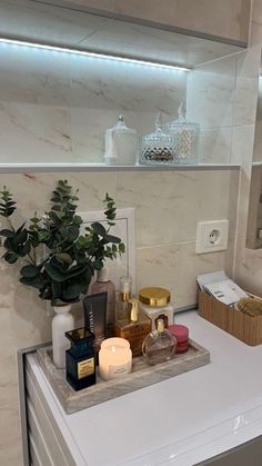 a bathroom vanity with candles, soaps and other items on the sink counter top