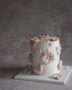 a three tiered white cake with flowers on it