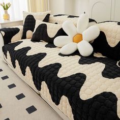 a black and white cow print couch with a flower on it's back cover