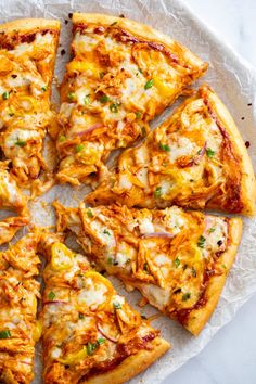 a pizza cut into eight pieces on top of a white plate with cheese and green onions