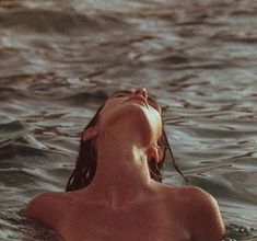 a woman swimming in the ocean with her head above water