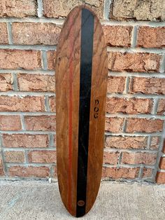 a wooden skateboard leaning against a brick wall with the number 3 on it's side