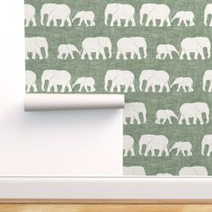 an elephant wallpaper with white elephants on a green background, next to a wooden floor