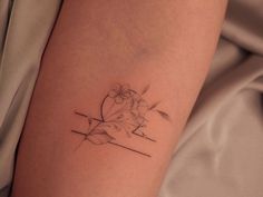 a woman's arm with a flower tattoo on the left side of her leg