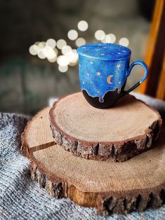 a blue cup sitting on top of a piece of wood