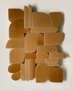 an abstract piece of art made out of cardboard and cut into smaller pieces, arranged on top of each other