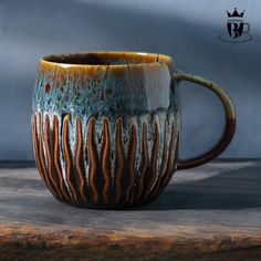 a brown and blue mug sitting on top of a wooden table