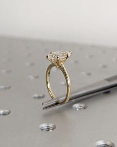 a diamond ring sitting on top of a table next to a pen and laptop computer