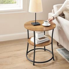 a woman sitting on a couch next to a table with a coffee cup on it